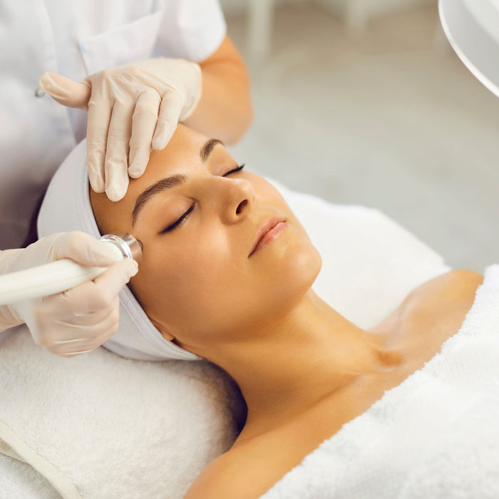 lady lying down getting electrical waves treatment on her face